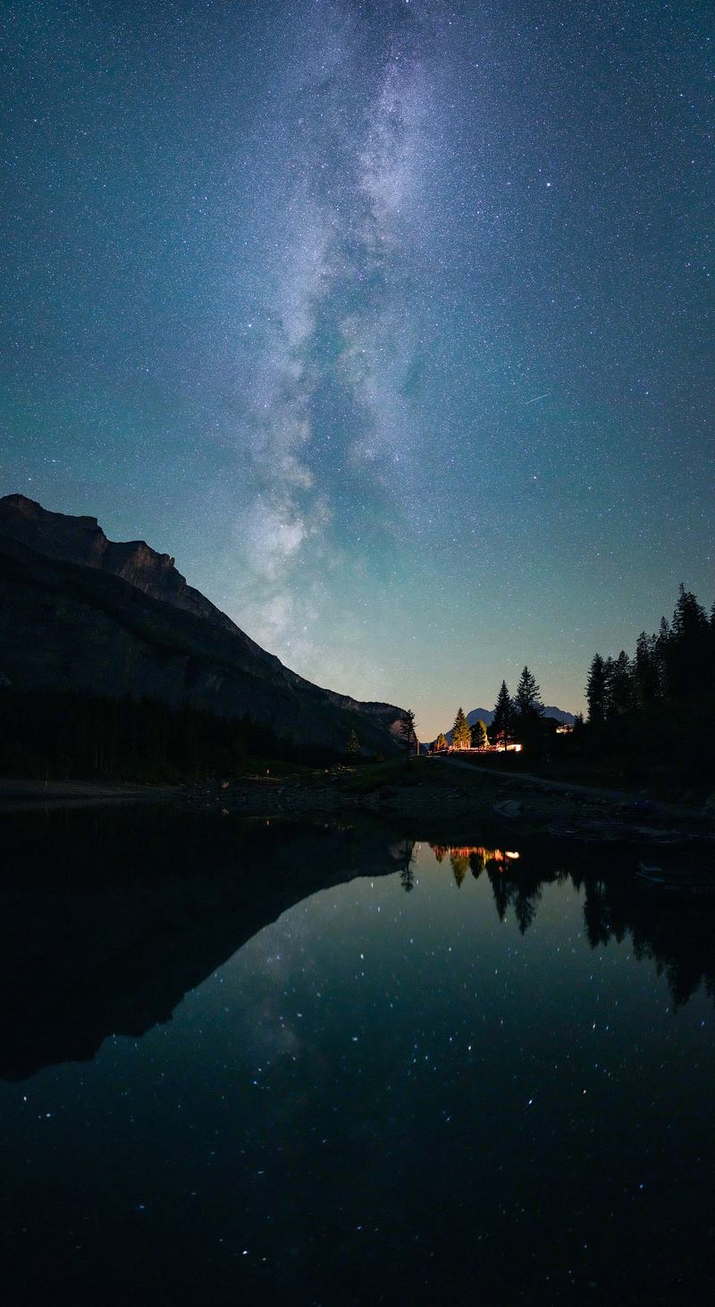 The Milky Way arching over a mountain lake at night