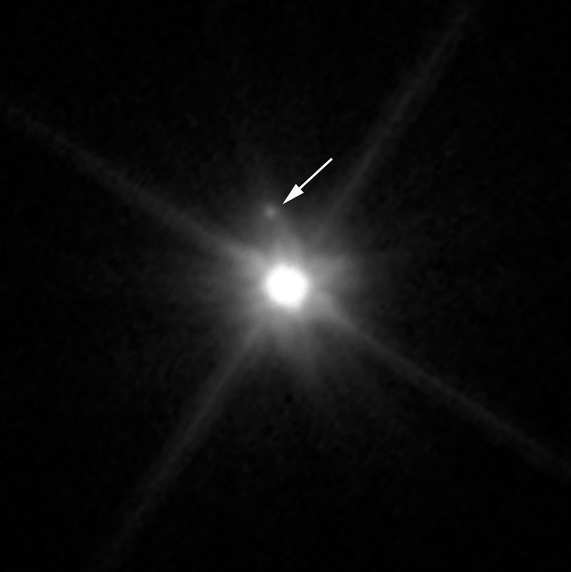 Image du télescope spatial Hubble de Makemake avec sa lune faible marquée par une flèche